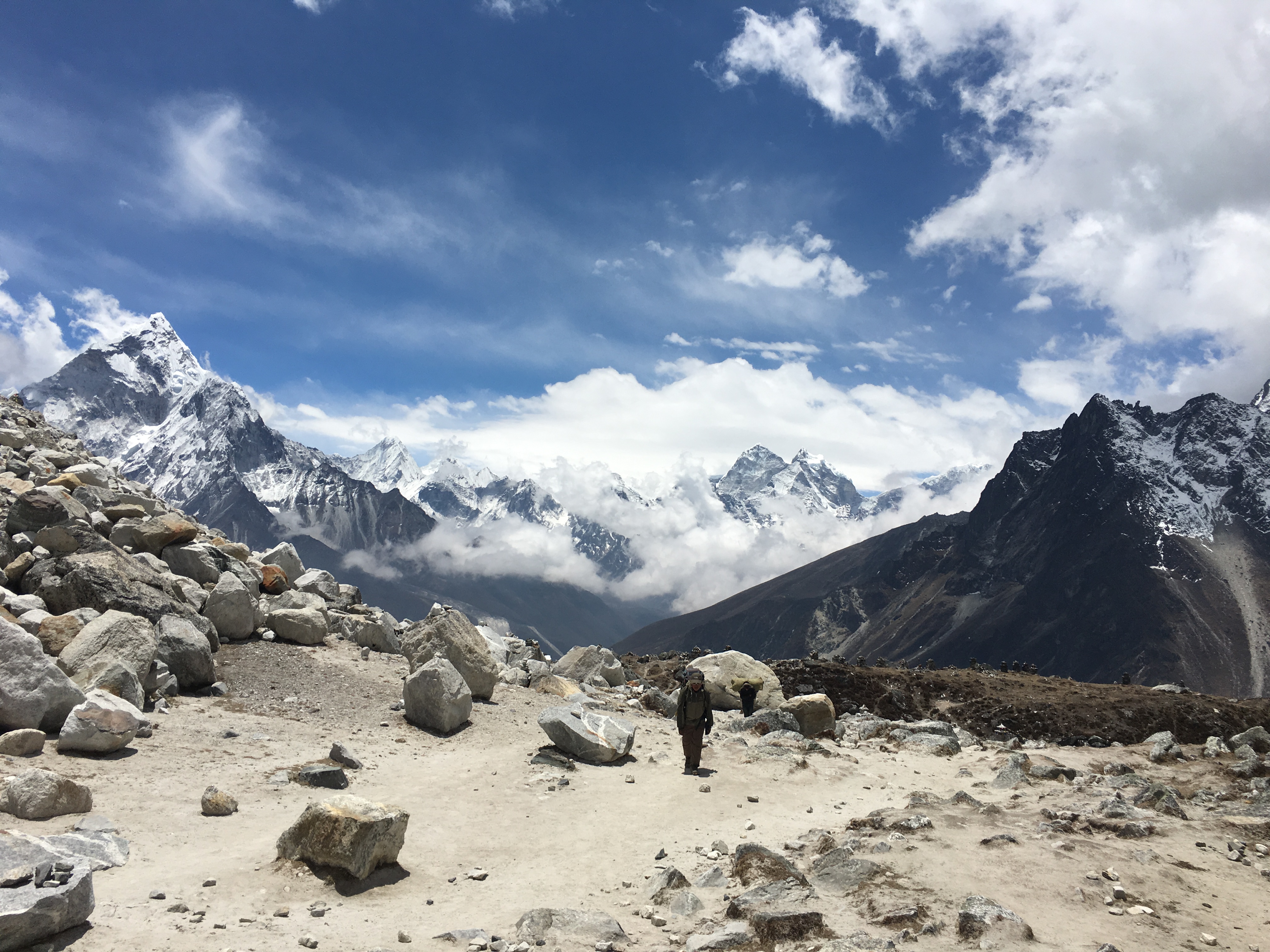 Sherpa in middle of the Himalayan mountains carrying gear as a porter.