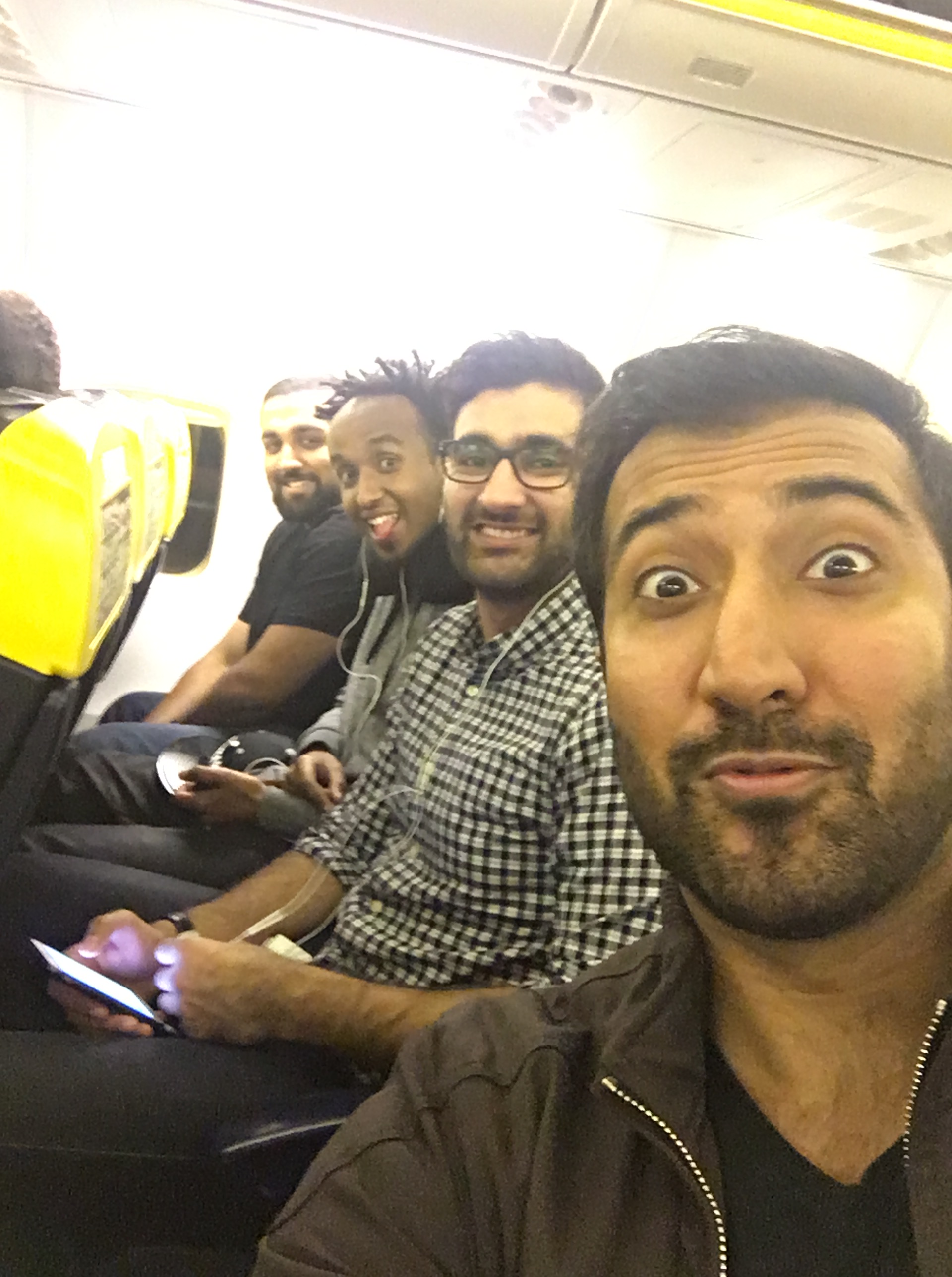 Zach, Aaqib, Leben and Qasim sitting together in a plane.