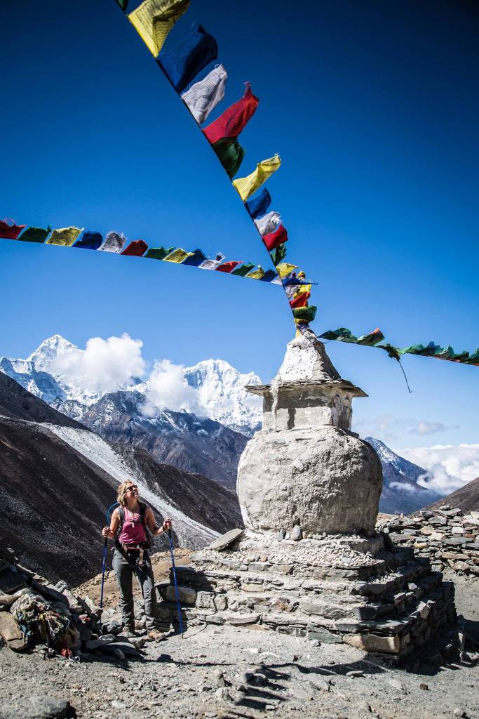 Fabienne standing below prayer flags