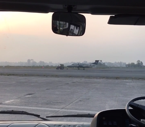 Tractor pulling plane across airport strip