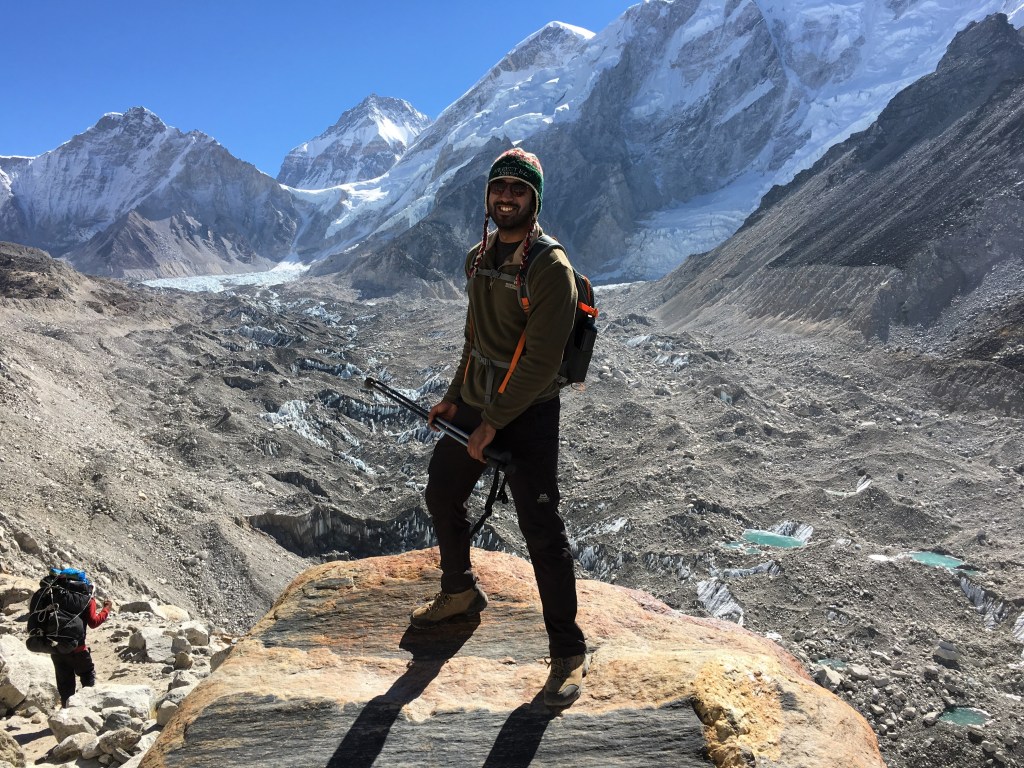 Zach posing with Everest base camp in the backdrop